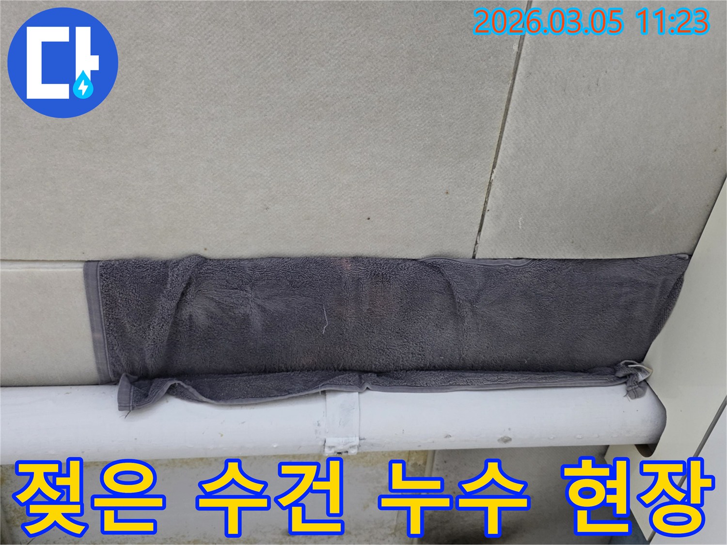 배관 누수로 인한 물방울을-수건으로 흡수하며 확산을 막는 장면-추가 손상을 방지하기 위한 임시방편