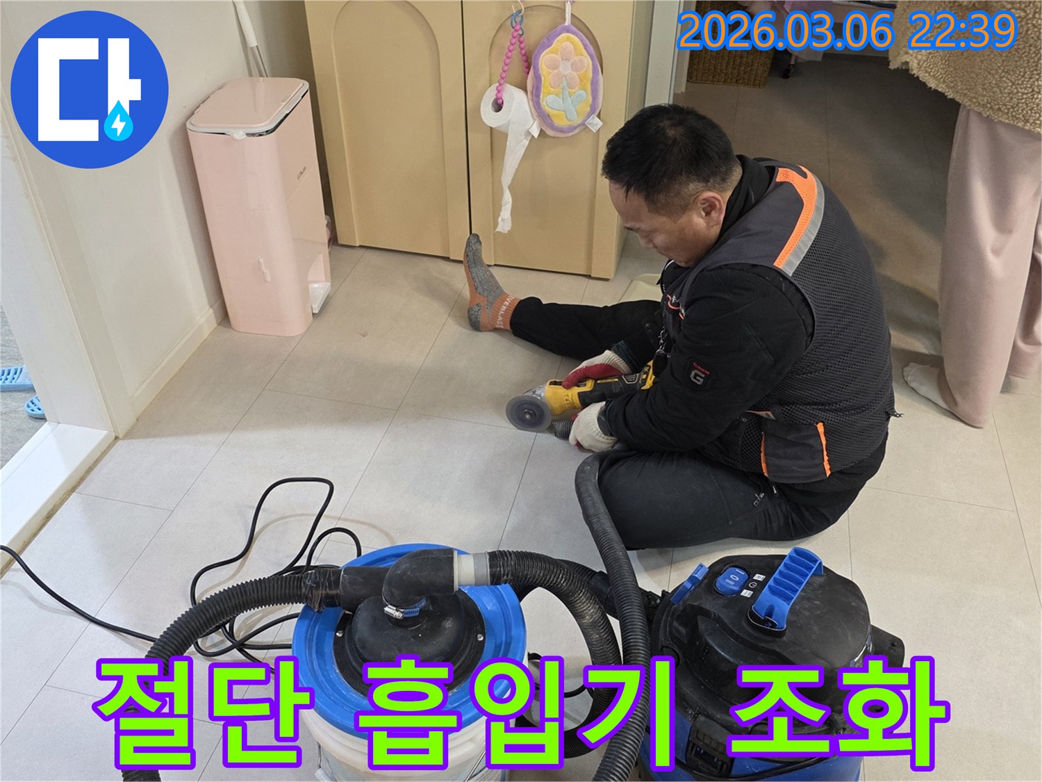 누수 공사 현장에서-절단기와 강력한 흡입기가 함께 사용되어-깨끗한 작업 환경을 유지하는 모습입니다.