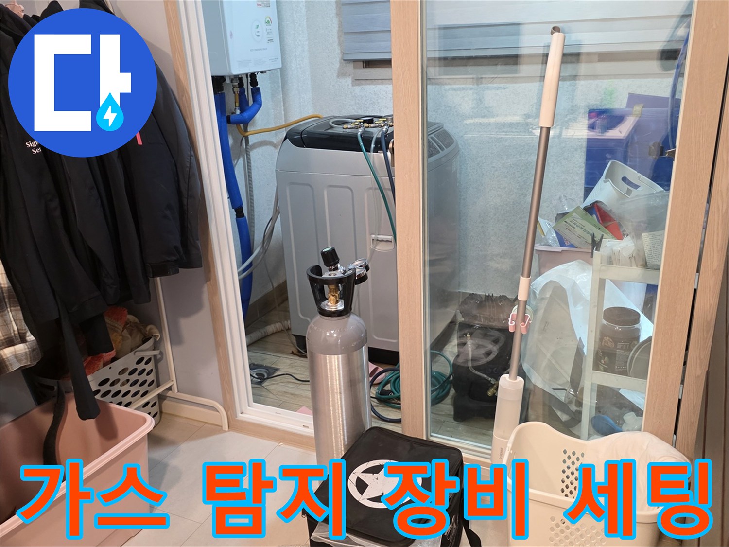 세탁실 배관 근처에 배치된-누수 탐지용 가스 실린더와 작업 도구들
