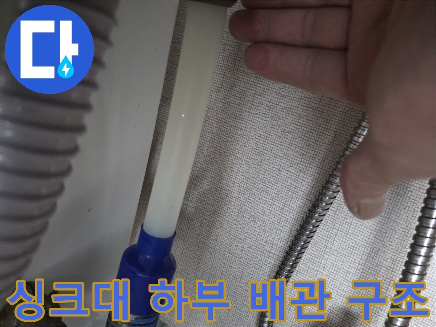 싱크대 아래쪽의 금속 보호관 및 연결 호스 상세 모습