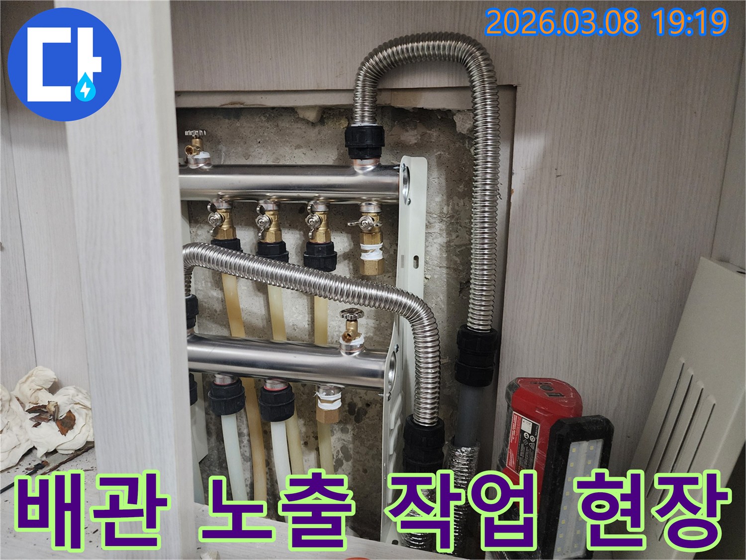 난방-분배기-및-배관-수리를-위해-벽면을-일부-노출시킨-모습으로-정밀한-작업이-진행되었음을-보여줍니다