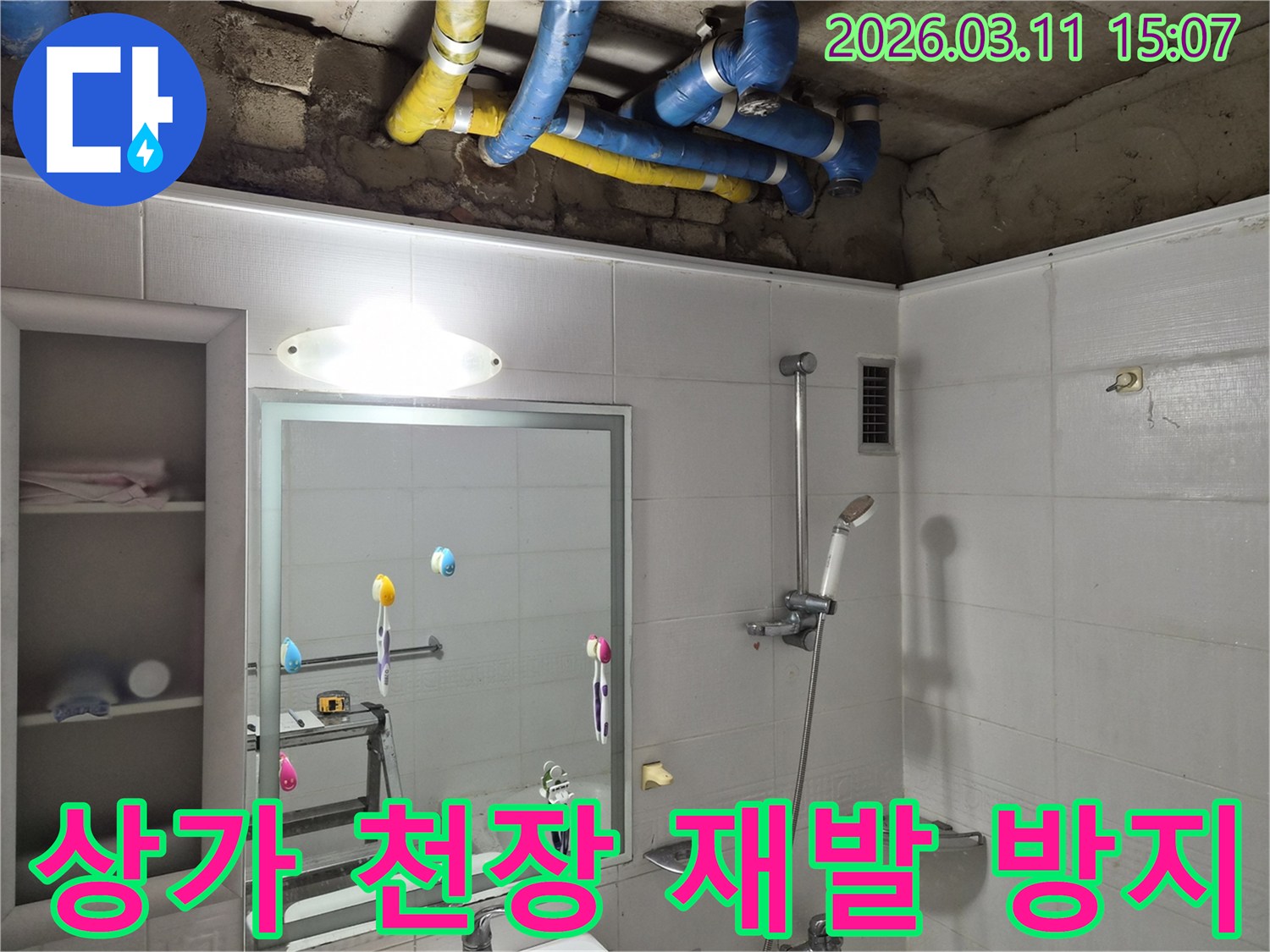 상가 욕실 천장 내부의-파란색과 노란색 배관들이-재발 방지를 위한-꼼꼼한 방수 점검을 위해-노출된 모습