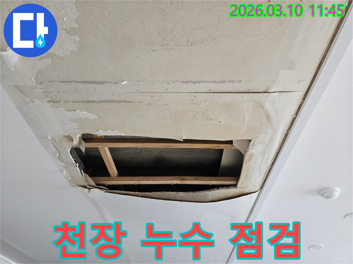 물이 새어-천장 벽지가 젖고-부풀어 오른 상태에서-내부 구조가 드러난-누수 현장입니다.