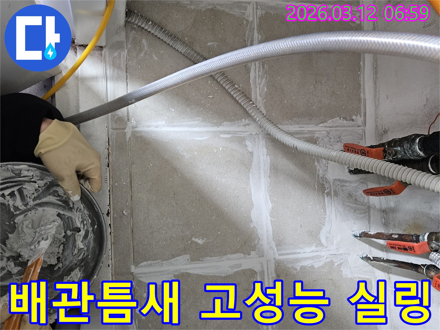 누수 엔지니어가 빌라 배관 주변 바닥의 미세한 틈새를 고성능 방수 실링재로 꼼꼼하게 시공하고 있습니다