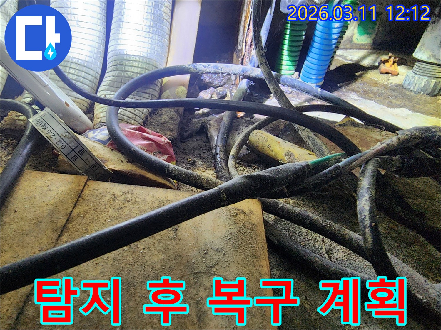 누수-현장에서-복잡하게-얽힌-배관과-전선-사이의-오염된-환경을-탐지한-후-복구-계획을-세우는-모습을-보여주는-사진입니다.