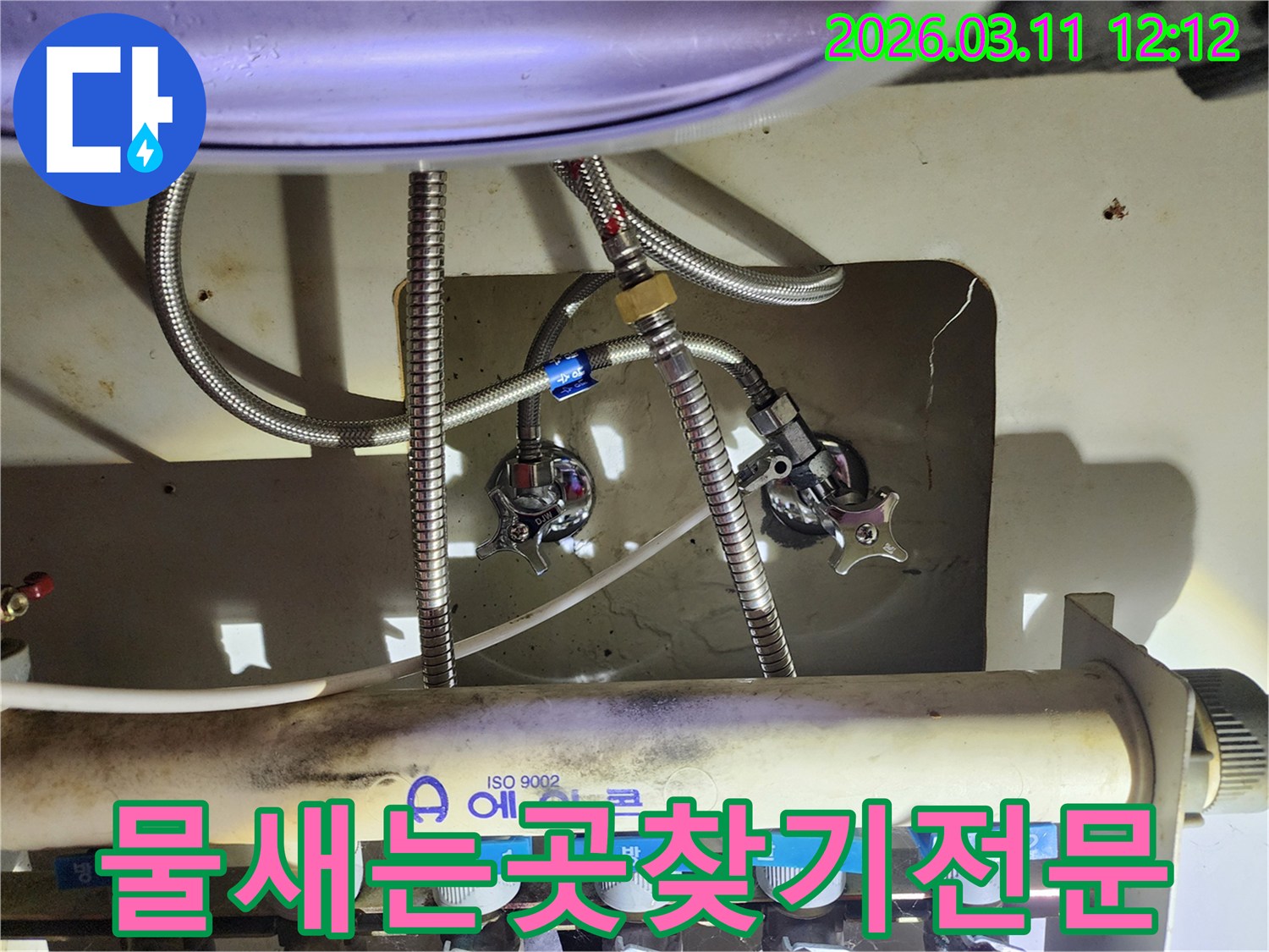 다수의-수도-배관과-밸브가-복잡하게-얽혀있는-싱크대-아래쪽-부분을-확대한-이미지