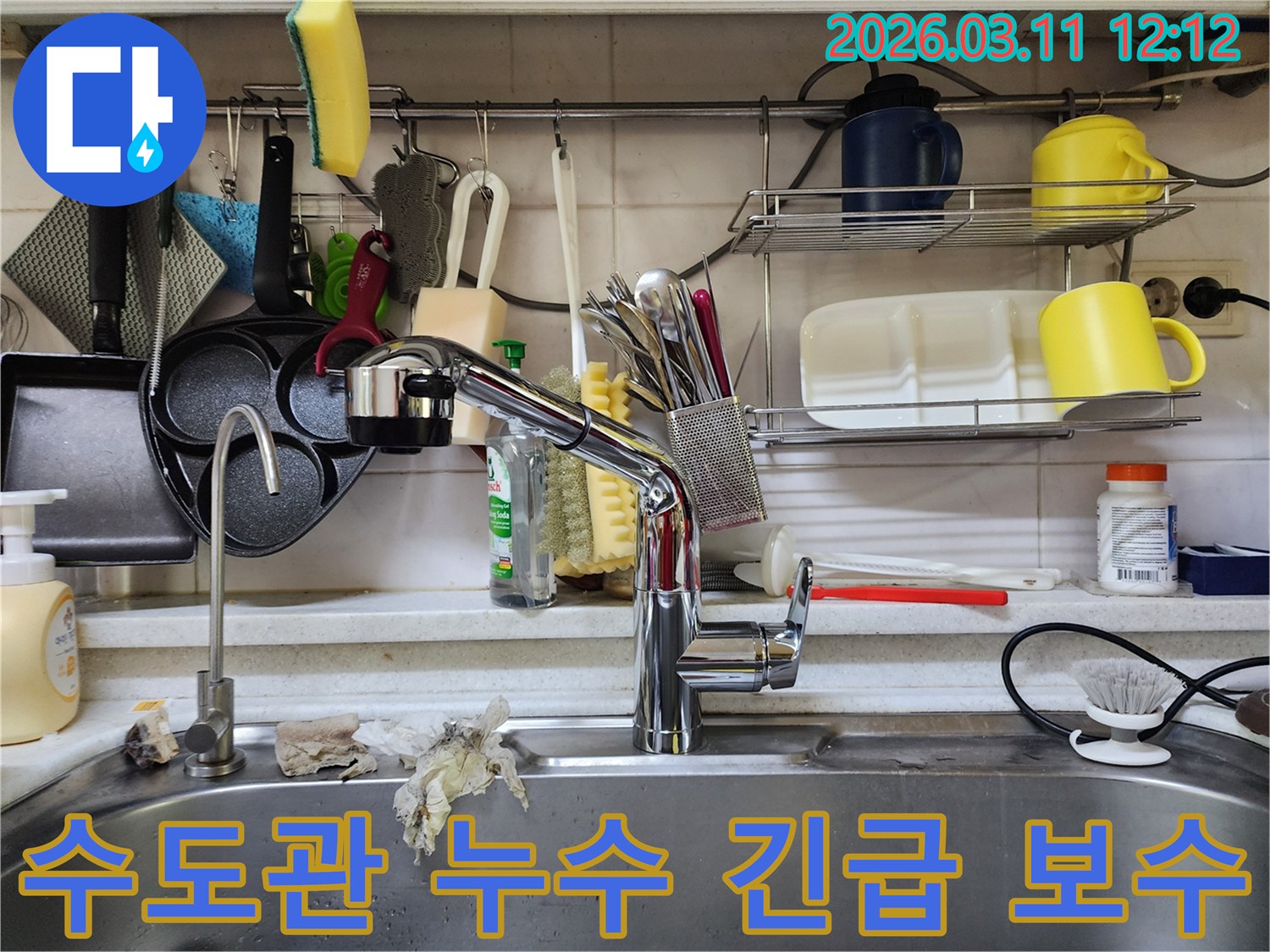 싱크대 수도관에서-갑작스럽게 발생한 누수를-전문가가 긴급하게-보수하는 현장 사진