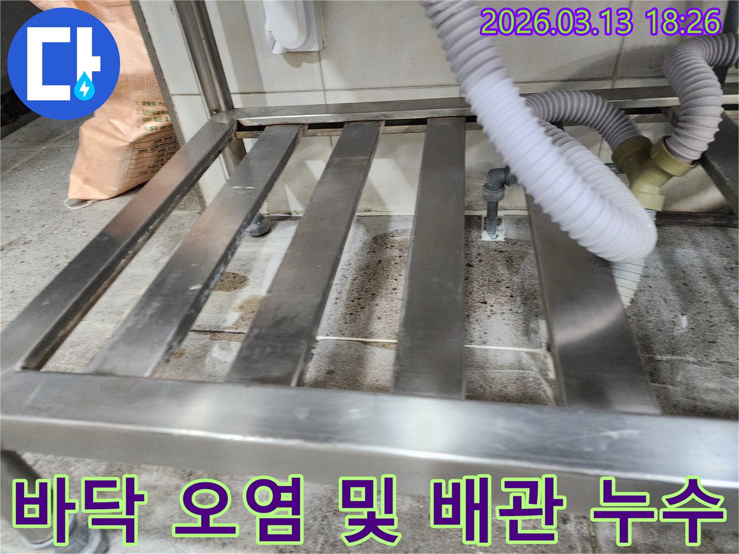 누수-현장에서-스테인리스 선반 아래-오염된 바닥과-배관 연결부를-정밀하게 점검하는 모습