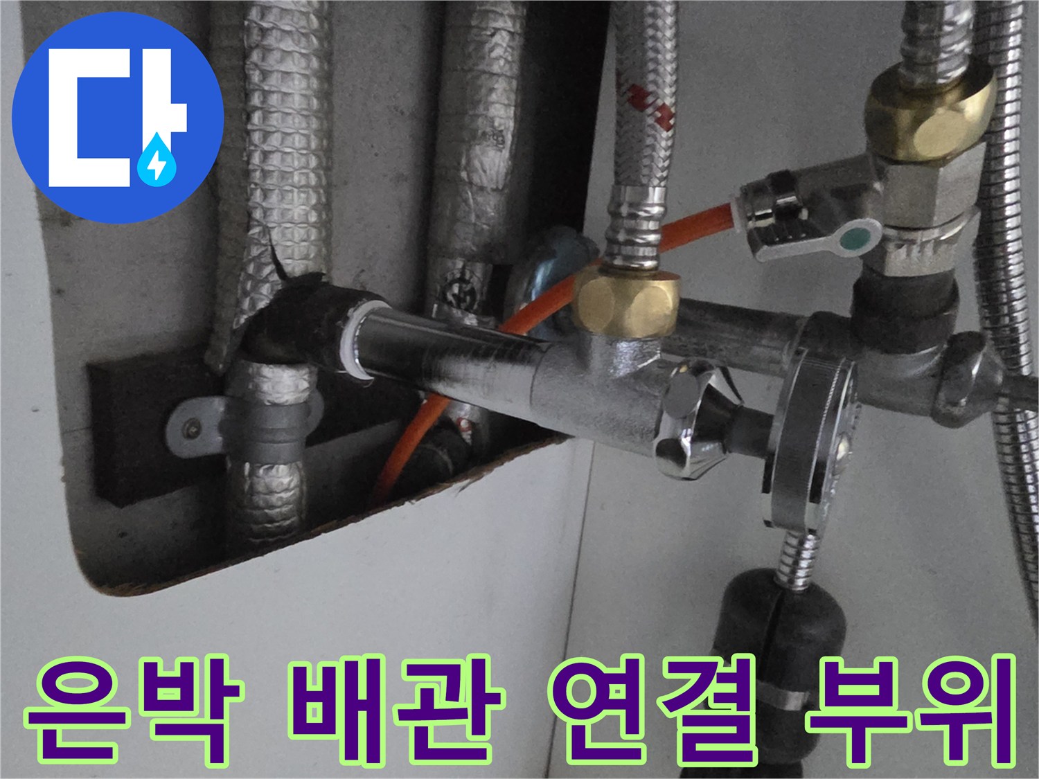 싱크대 하부-연결된 은색 배관과 밸브 장치