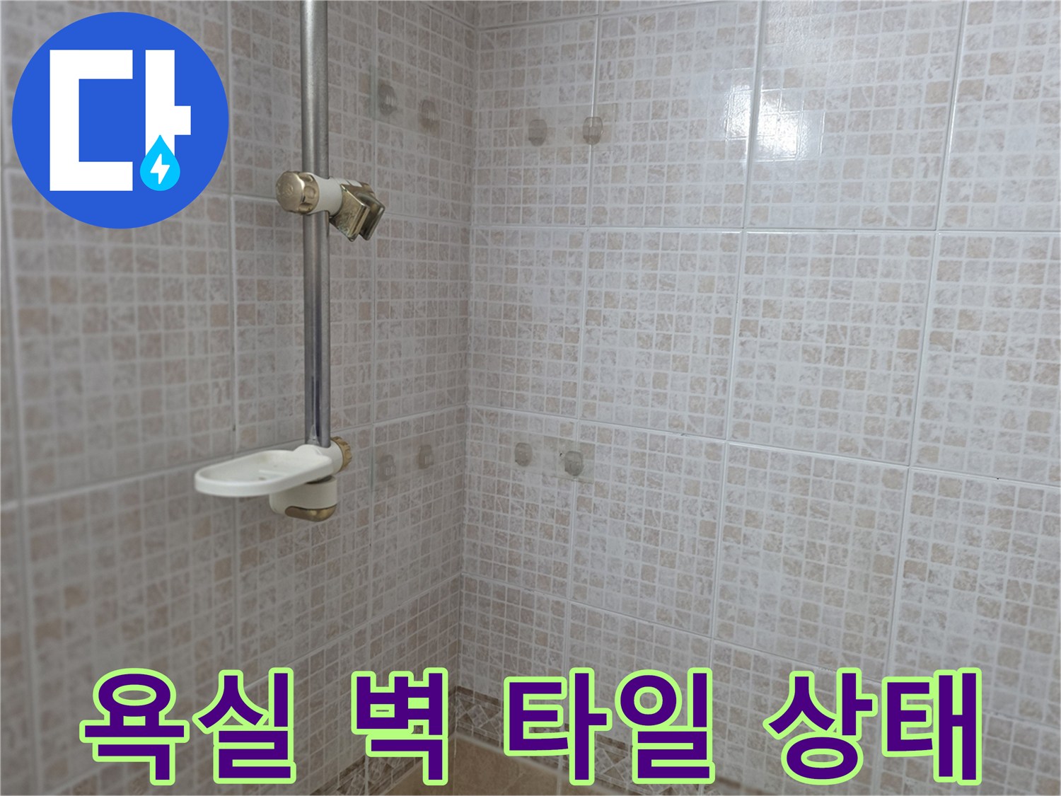 샤워 수전과 연결된 욕실 내부 타일 벽면 사진