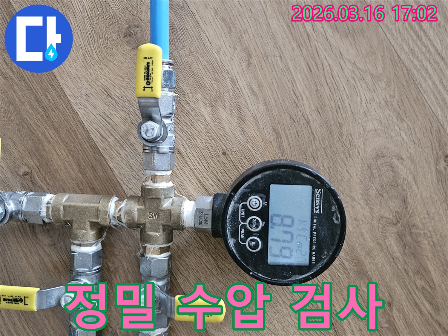 누수 탐지 엔지니어가-배관에 디지털 압력계를 연결하여-숨겨진 누수 지점을 찾아내기 위한-정밀 수압 검사를 진행하는 모습입니다.