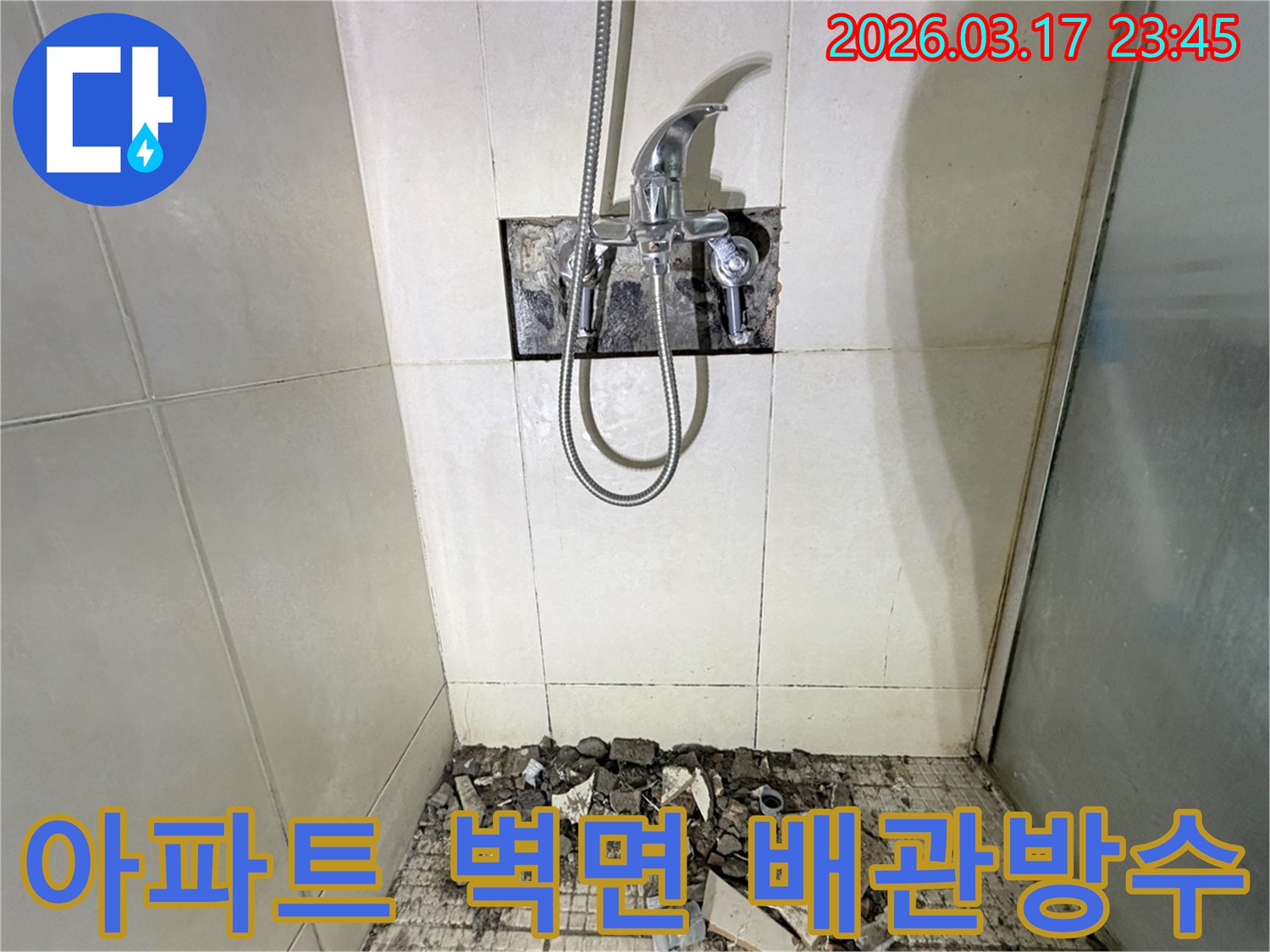 경기 화성시 병점동 아파트 욕실에서-벽면 수도 배관 노후 누수 부분 교체 및 방수 강화를 위해-샤워 수전이 제거되고-바닥 타일이 파손된 채로-공사가 진행 중인 모습입니다.