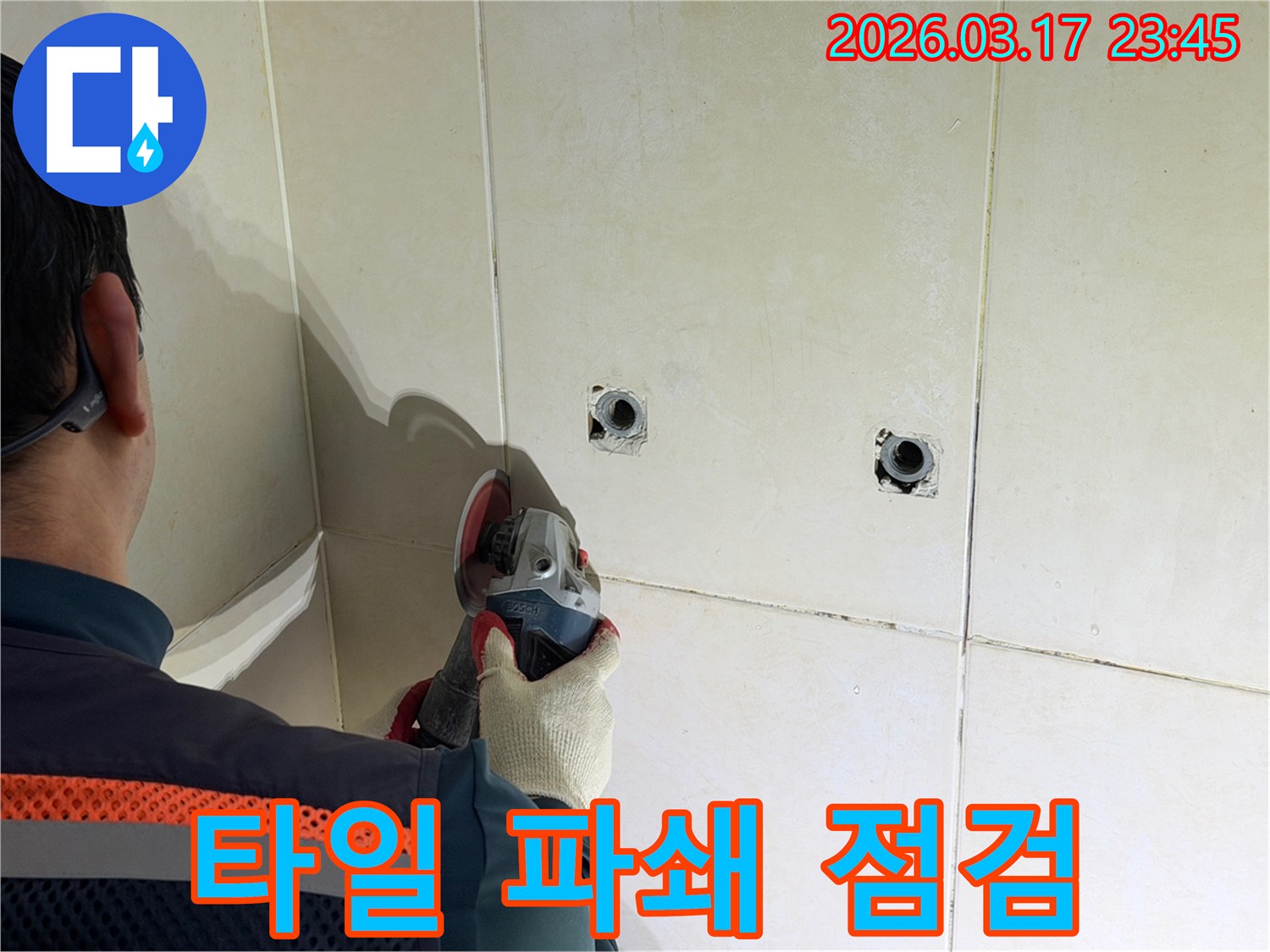 누수 지점 확인 후-전문가가-타일 벽면을-파쇄하고-배관을-점검하는-작업을-진행하고-있습니다