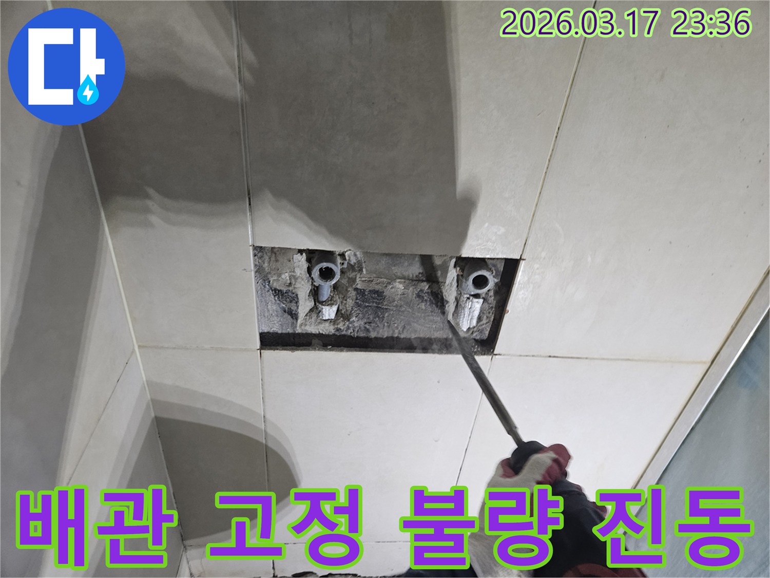 누수 해결을 위한-필수 단계로-벽면 타일 파쇄 후-배관을 노출하여-배관 고정 불량으로 인한-진동 누수를-확인하는 모습입니다