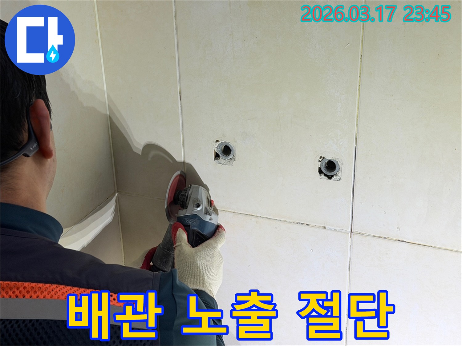 누수된 배관을-노출시키기 위해-전문가가-타일 벽면을-그라인더로-조심스럽게-절단하는-작업을-진행하고-있습니다