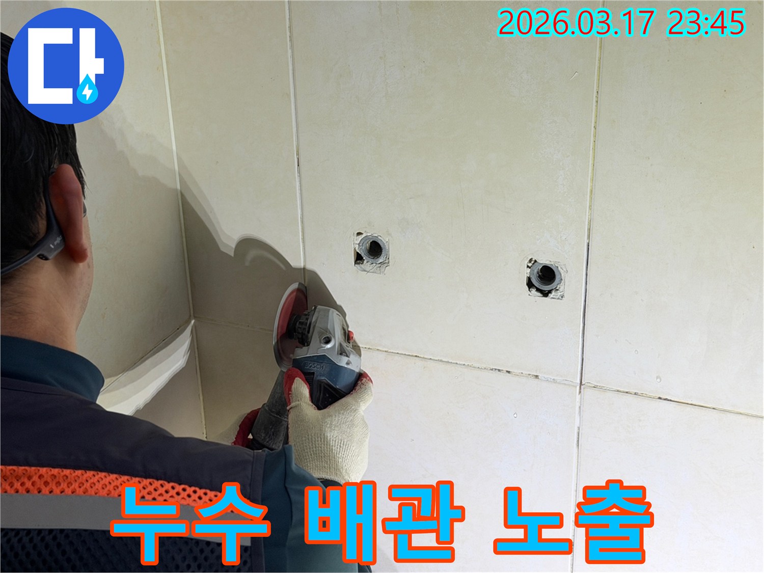 누수된 배관을-노출시키기 위해-전문가가-타일 벽면을-그라인더로-조심스럽게-커팅하고-있습니다