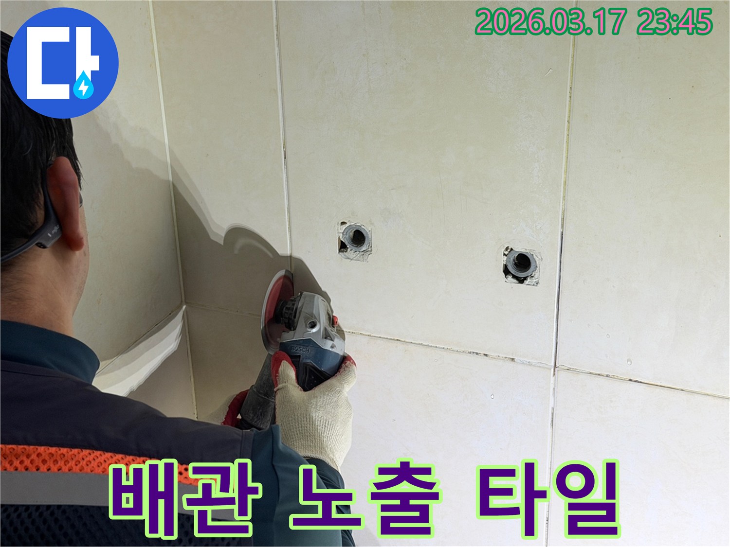 누수된 배관을-노출시키기 위해-전문가가-타일 벽면을-그라인더로-조심스럽게-커팅하고-있습니다