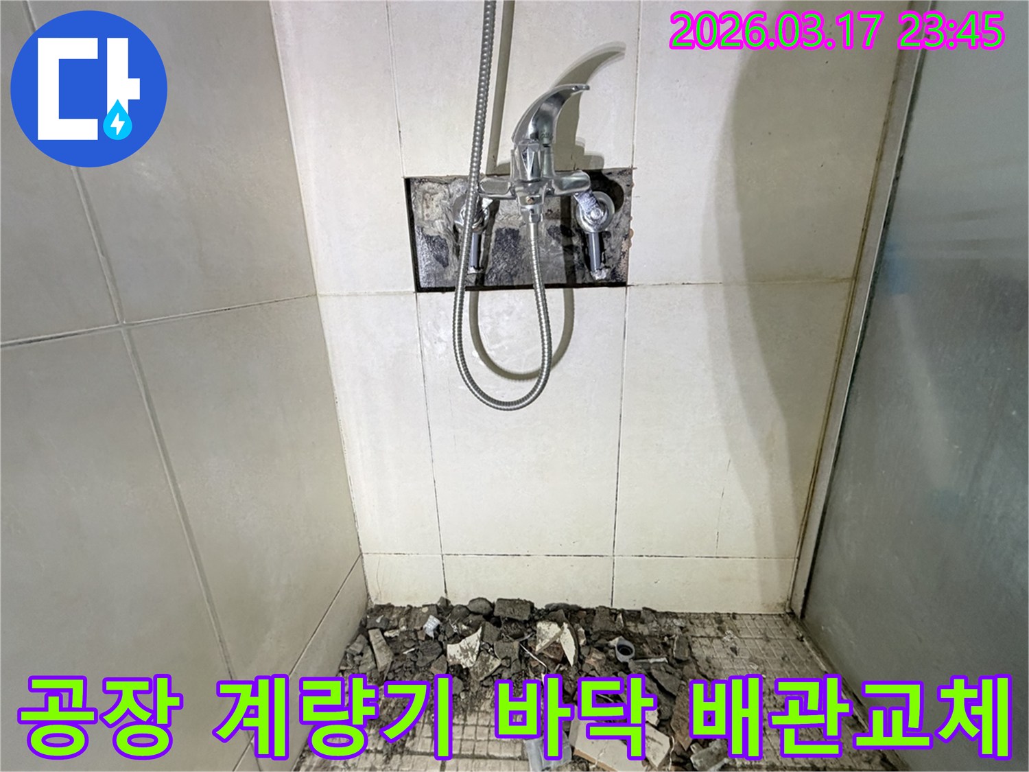 병점구 공장 화장실에서-수도 계량기 누수 배관 점검 및 교체를 위해-바닥 타일이 파손된 채로-공사가 진행 중인 모습입니다.