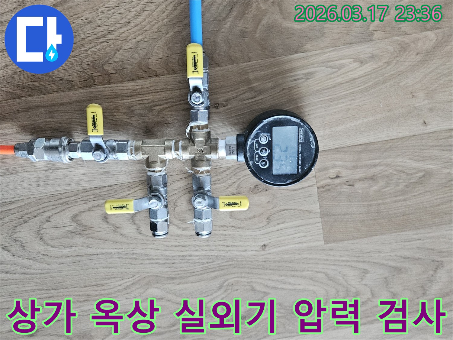 상가 옥상 에어컨 실외기 배관의 누수 여부를 확인하기 위해-정밀한 압력 테스트 장비를 연결하여-수치를 측정하고 있습니다.