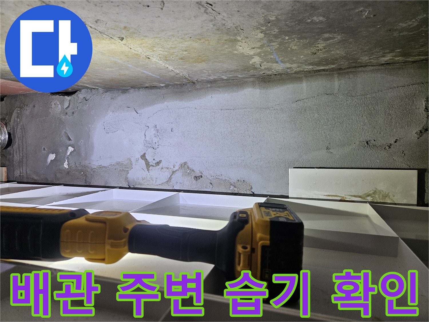 손전등 빛으로 비춰본 배관 주변의 젖은 벽면