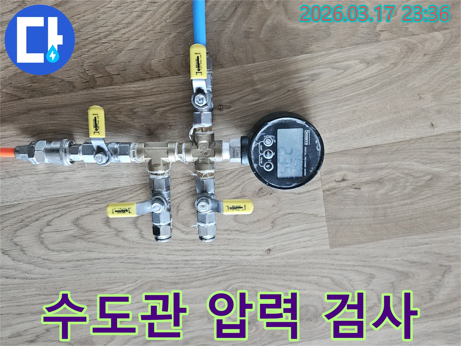 수도관의 누수 여부를 확인하기 위해-정밀한 압력 테스트 장비를 연결하여-수치를 측정하고 있습니다.