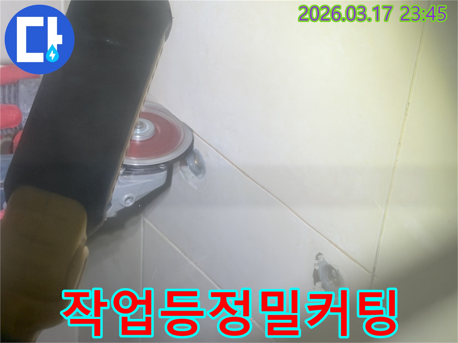 욕실-누수-수리-중-작업등으로-밝히며-타일을-정밀하게-커팅하는-모습입니다.