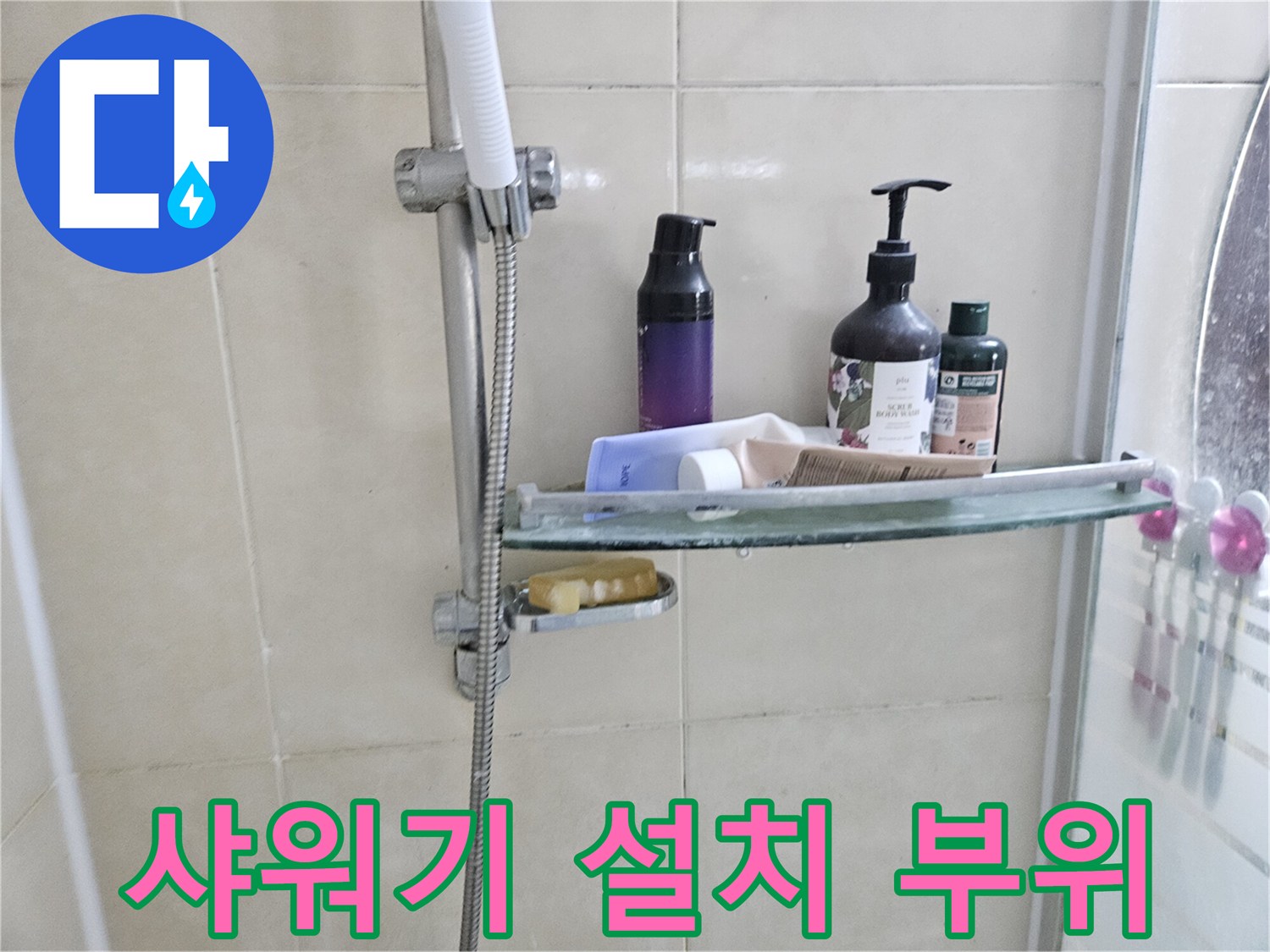 욕실 선반과 샤워기 수전이 있는 타일벽 사진입니다.