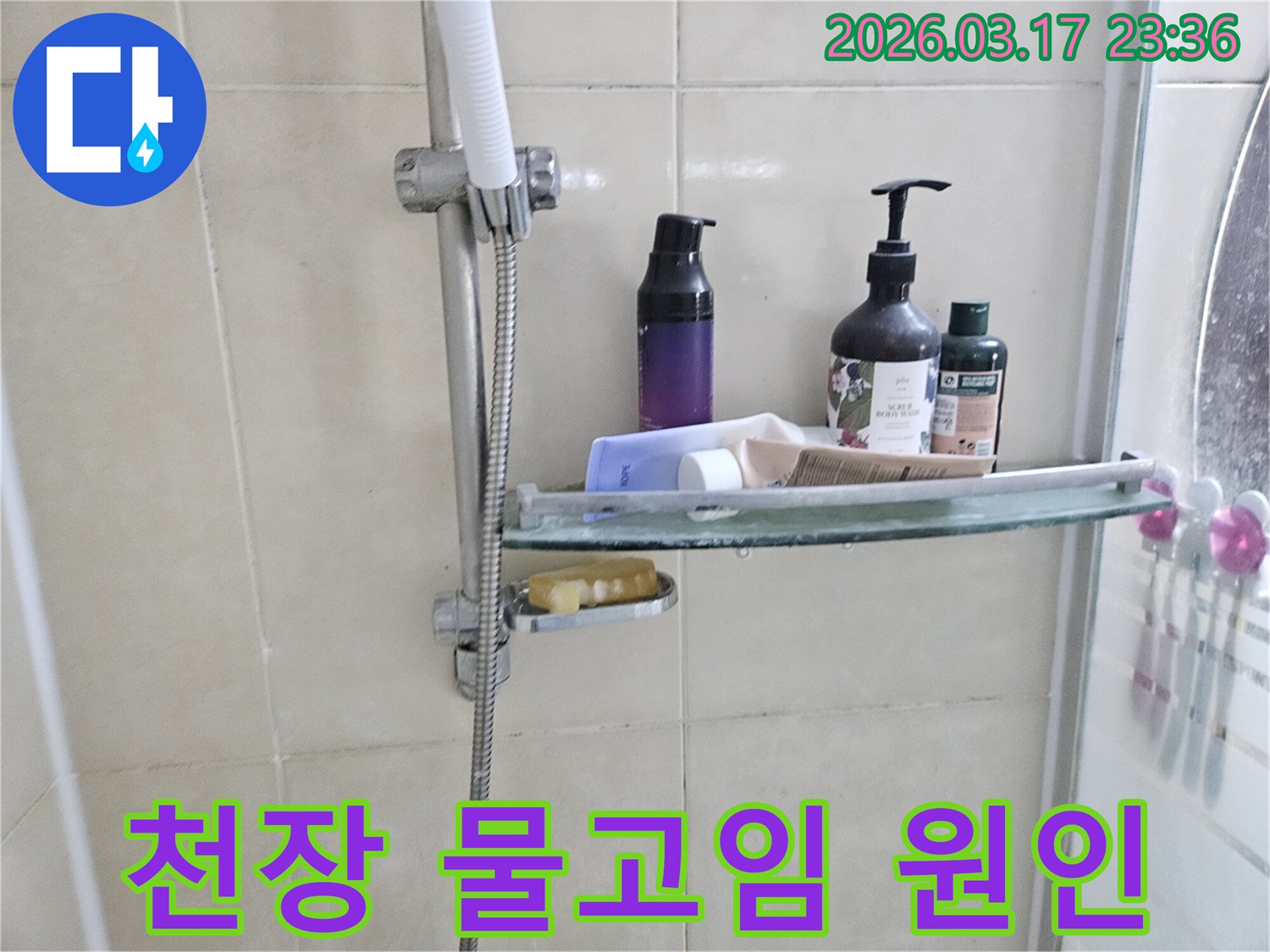 화장실 샤워기 옆-유리 선반에 맺힌 물방울은-천장 물고임의 간접적인 증거를 보여주는 이미지입니다