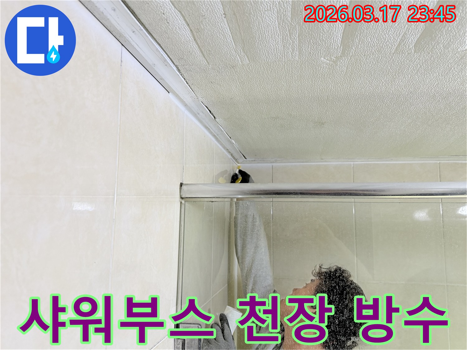 화장실 샤워부스 상단-천장 접합부에서 발생한 누수 문제를 해결하기 위해-실리콘 보수 작업을 진행하는 전문가의 모습입니다.