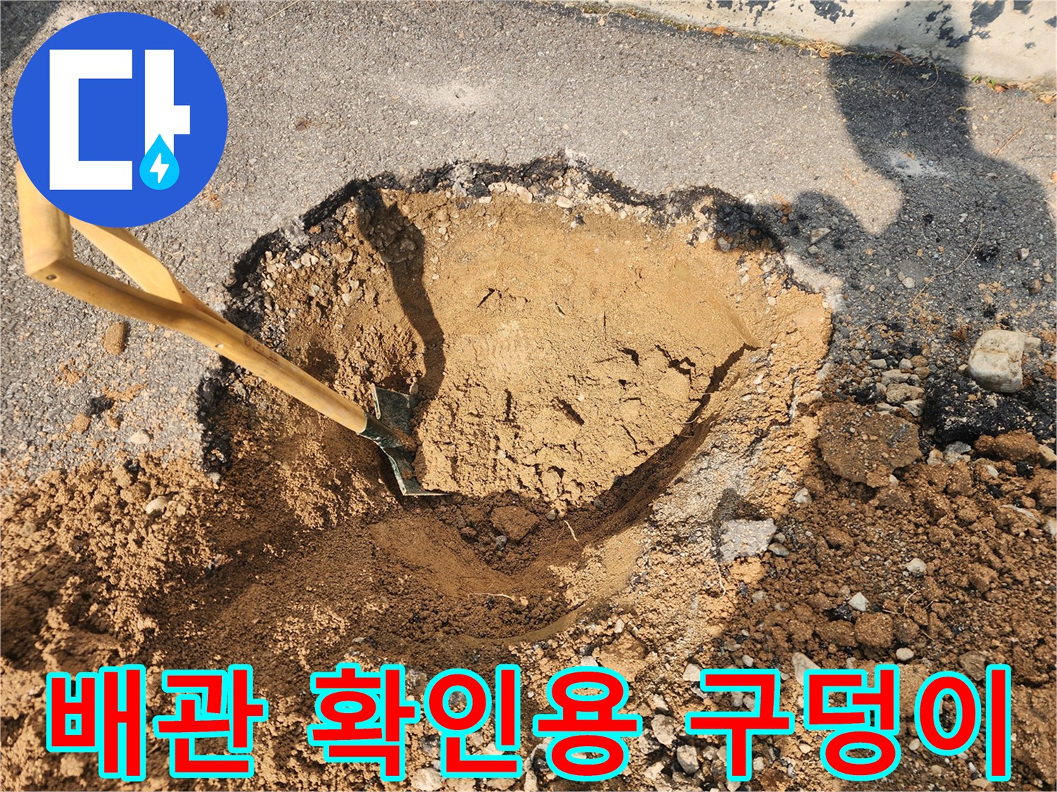 삽으로 파헤쳐진 흙과 아스팔트 경계의 굴착 작업 장면