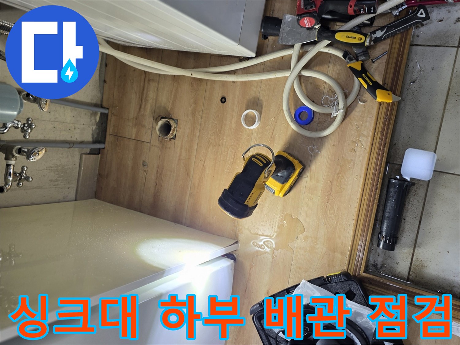 싱크대 하단 공간에서 진행 중인 공압 테스트 장비와 배관 상태