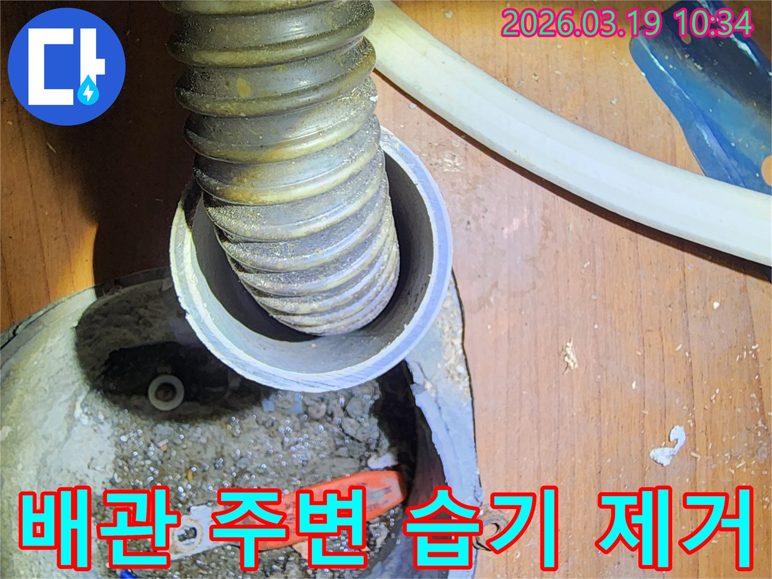 이 이미지는-성동구 사근동의-누수 현장에서-배관 주변의-습기를 제거하고-건조하는 작업을-보여줍니다