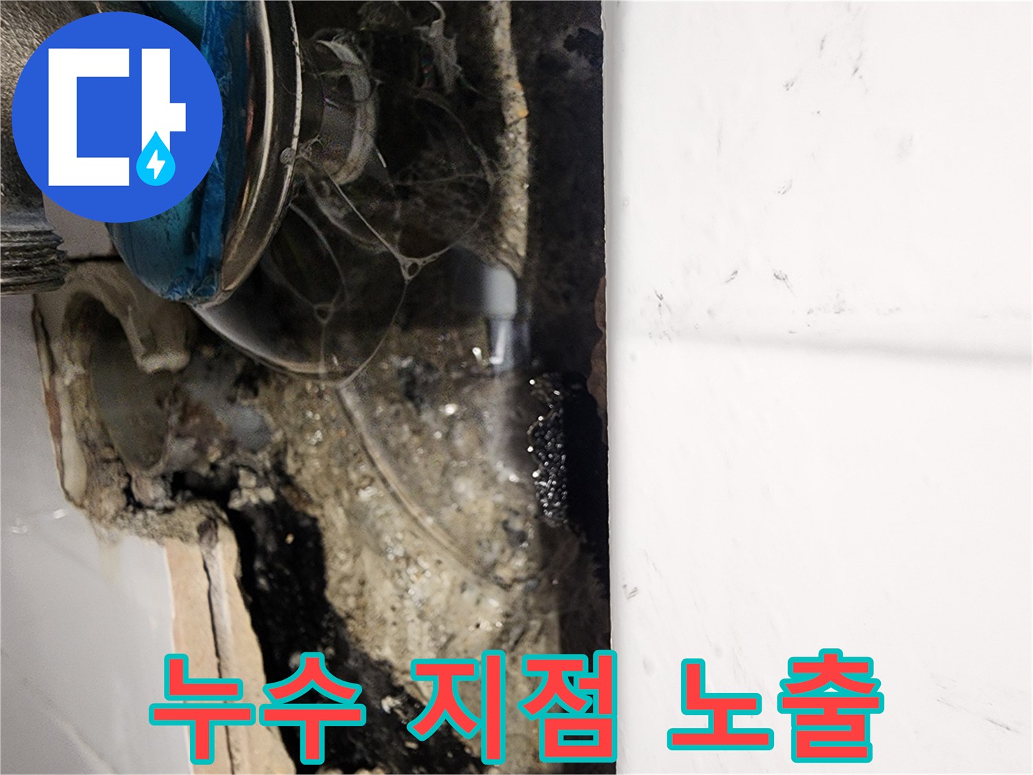 벽면 타일 안쪽의 젖은 콘크리트와 노출된 수도 부속품