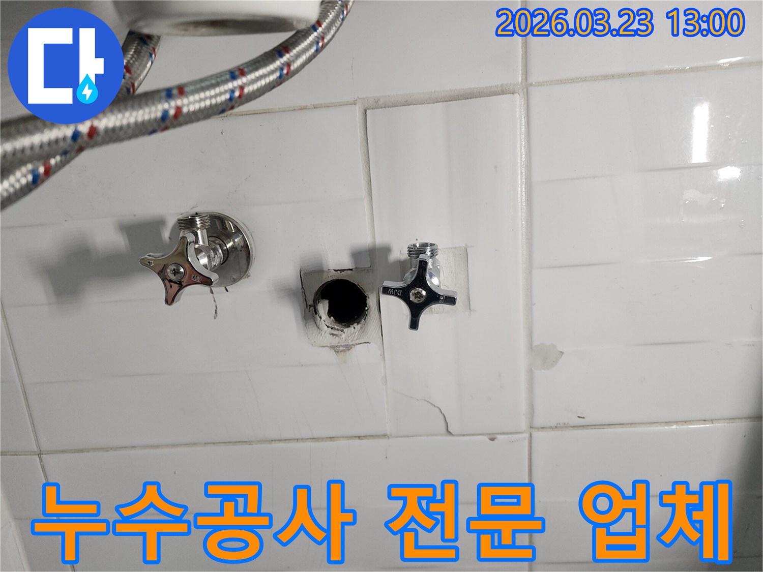 하얀색 타일 벽면의-수도 배관 연결 부위에서-누수가 확인되어-타일을 제거하고-배관을 점검하는-누수 현장입니다.