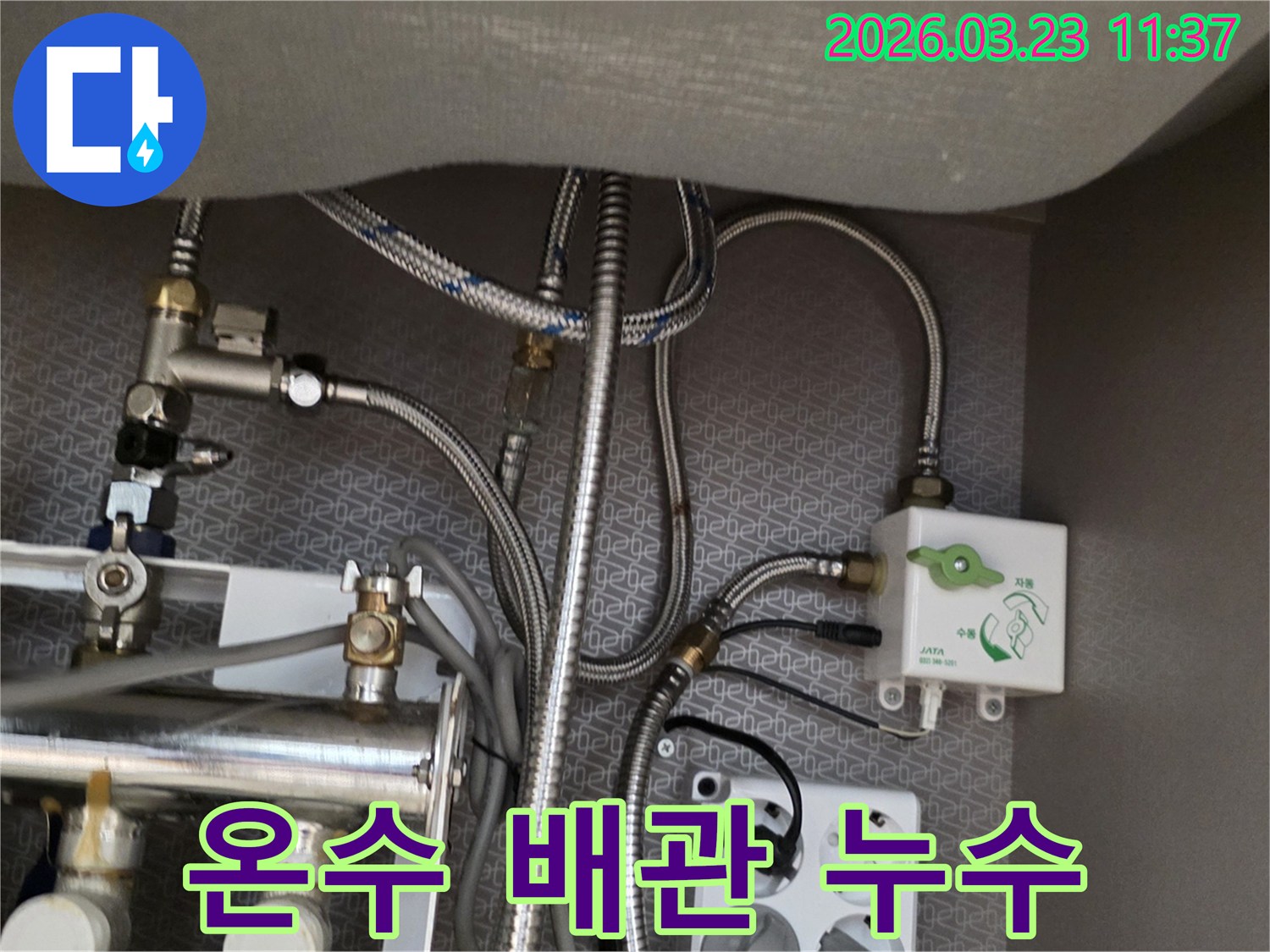 싱크대 하부장 내부의 온수-배관과 정수기-밸브-수도-호스-전기 콘센트가-보이는 곳에서-누수 흔적을-찾아내고 있습니다.