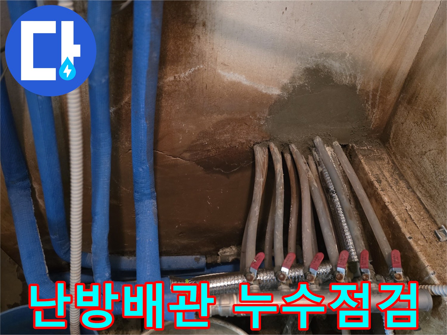 파란색 보온재로-감싸진 난방 배관의 분배기 연결 모습