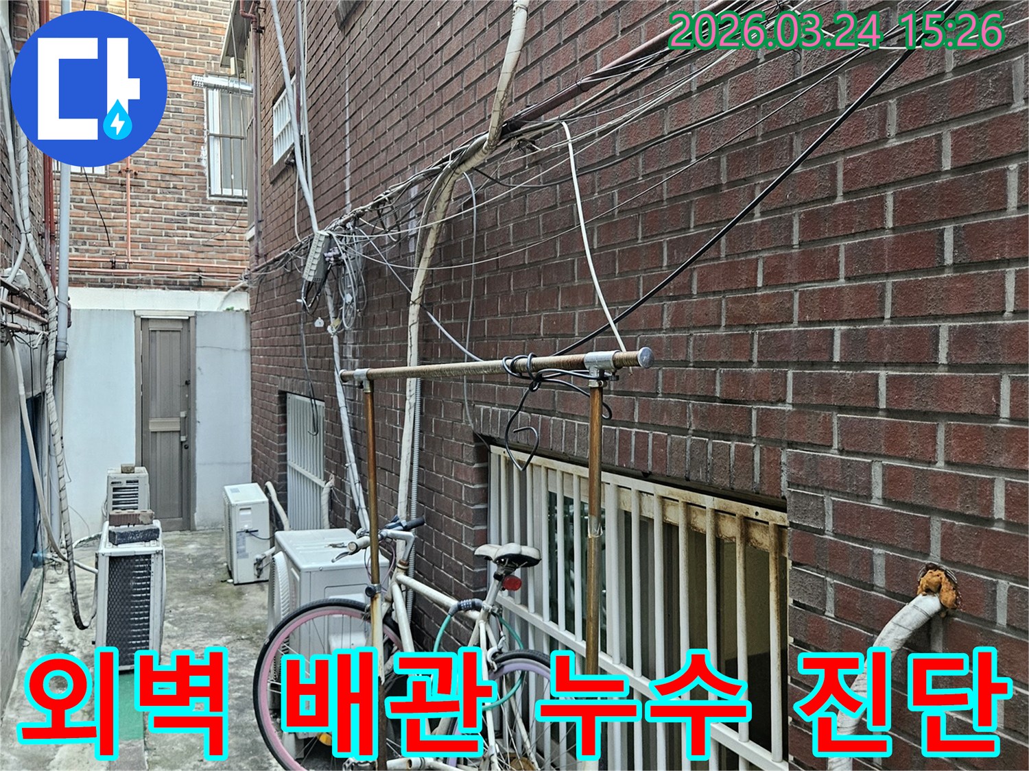 오래된 건물 외벽에-복잡하게 얽힌 배관과-전선-누수탐지 전 현장 점검