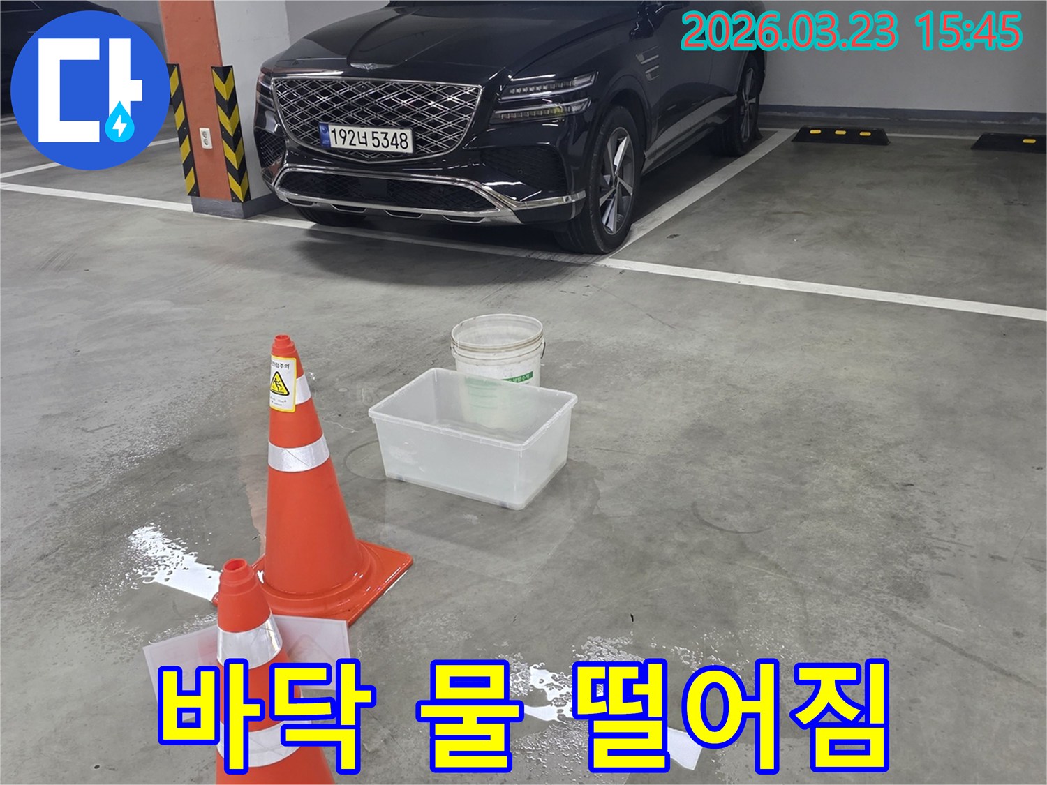 지하주차장 바닥에 물이 고여-안전 콘과 물통으로 임시 조치된-누수 현장입니다.