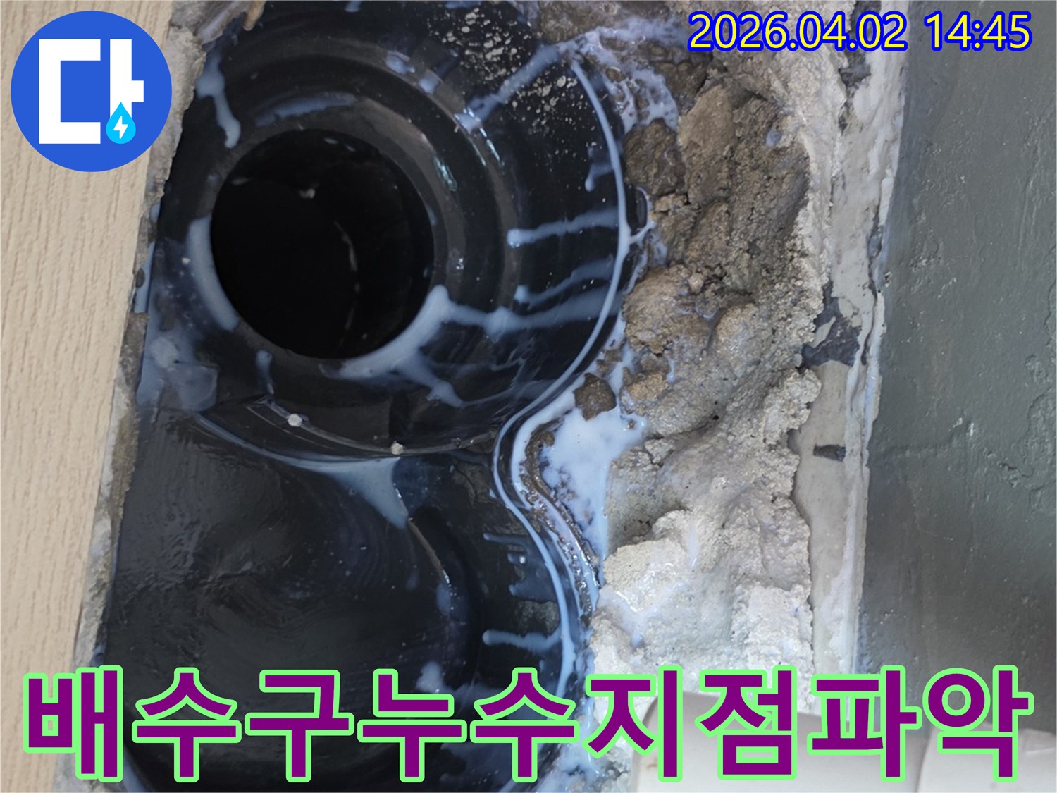 구리시의 한 현장에서-배수구 주변의 누수 지점을-특수 탐지액을 사용하여-정확하게 파악하는-작업 현장을 담은 이미지입니다.