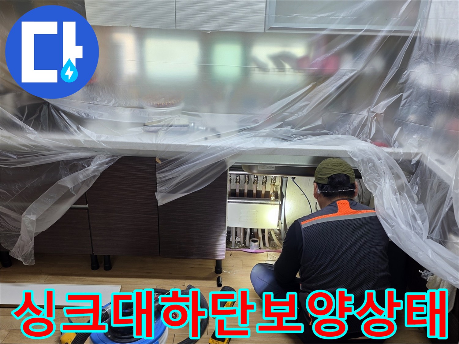 비닐로 덮인 싱크대 하부 공간과 작업 준비 장비