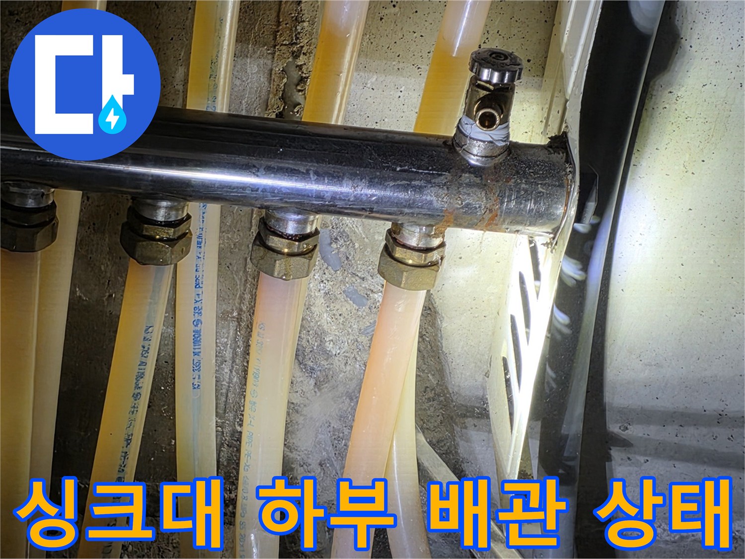 싱크대 아래쪽 유연한 배수 호스와 금속 관의 연결 구조
