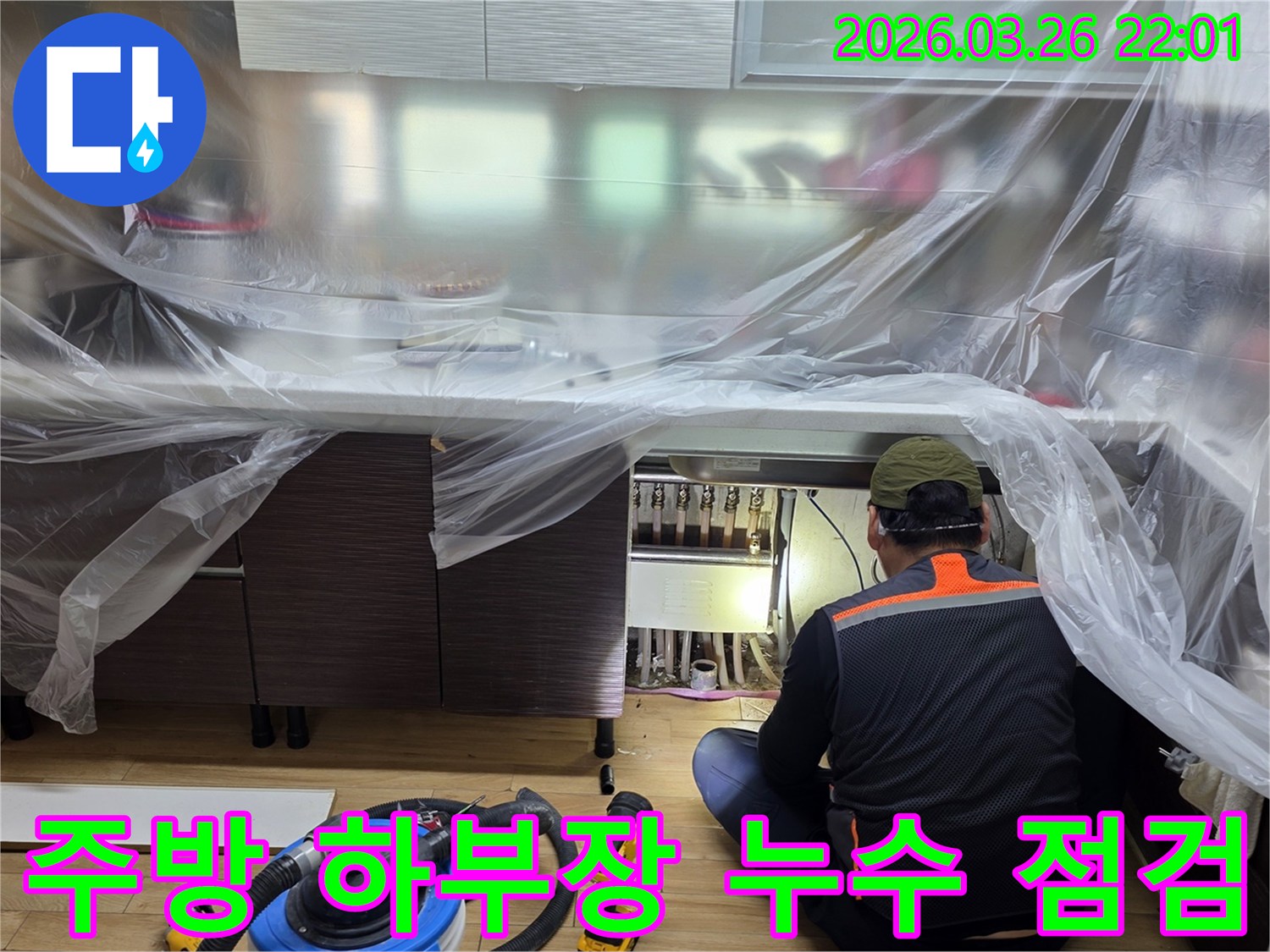 전문 엔지니어가-주방 싱크대 아래-배관 연결 부위의-누수 여부를-집중적으로-살펴보고 있습니다.