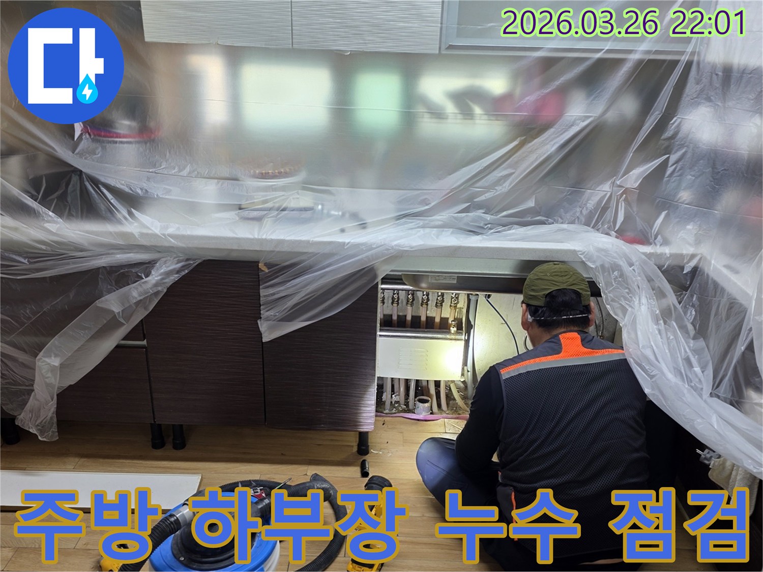 전문 엔지니어가-주방 싱크대 아래-배관 연결 부위의-누수 여부를-집중적으로-살펴보고 있습니다.