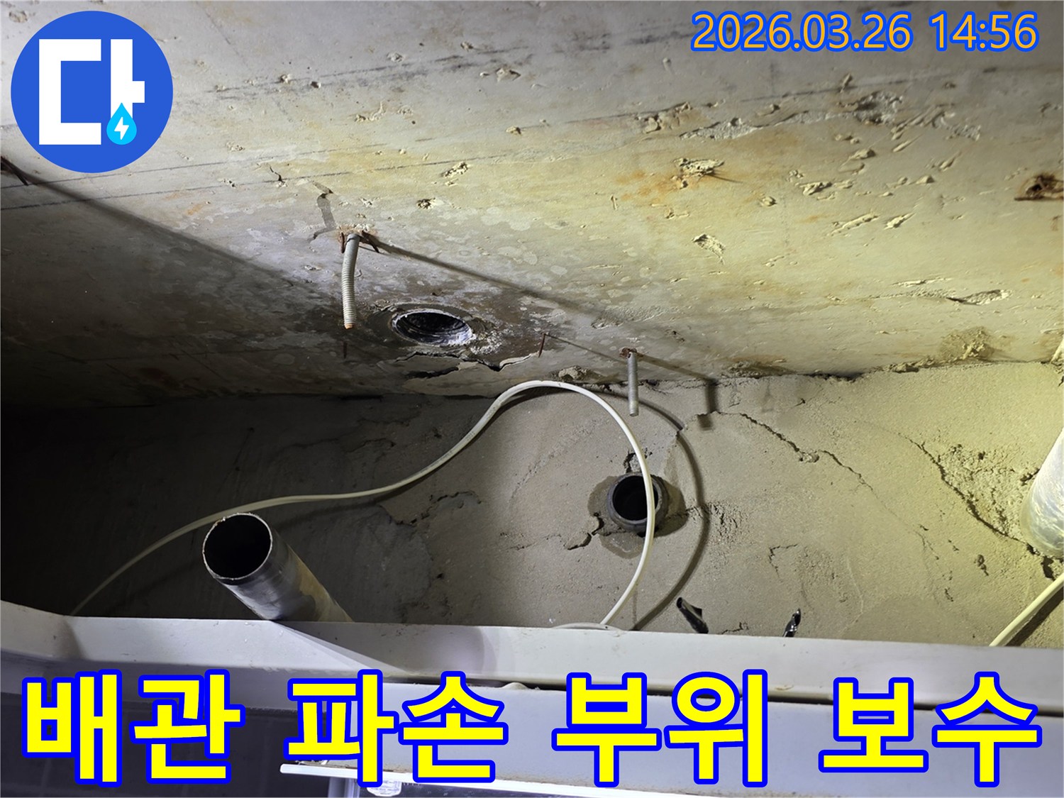이 사진은-천장 배관의 파손 부위에서-발생한 누수를-전문가가 정밀하게 보수하는-공사 현장을 보여줍니다.