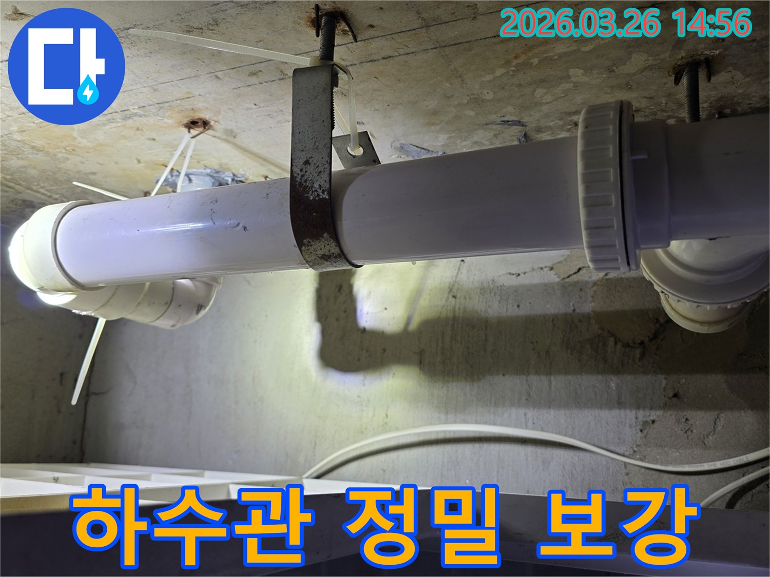 콘크리트 천장에 고정된-하얀색 하수관의 연결 부위와-녹슨 지지대를 점검하는 모습으로-정밀 탐지 후 보강 작업을 보여줍니다
