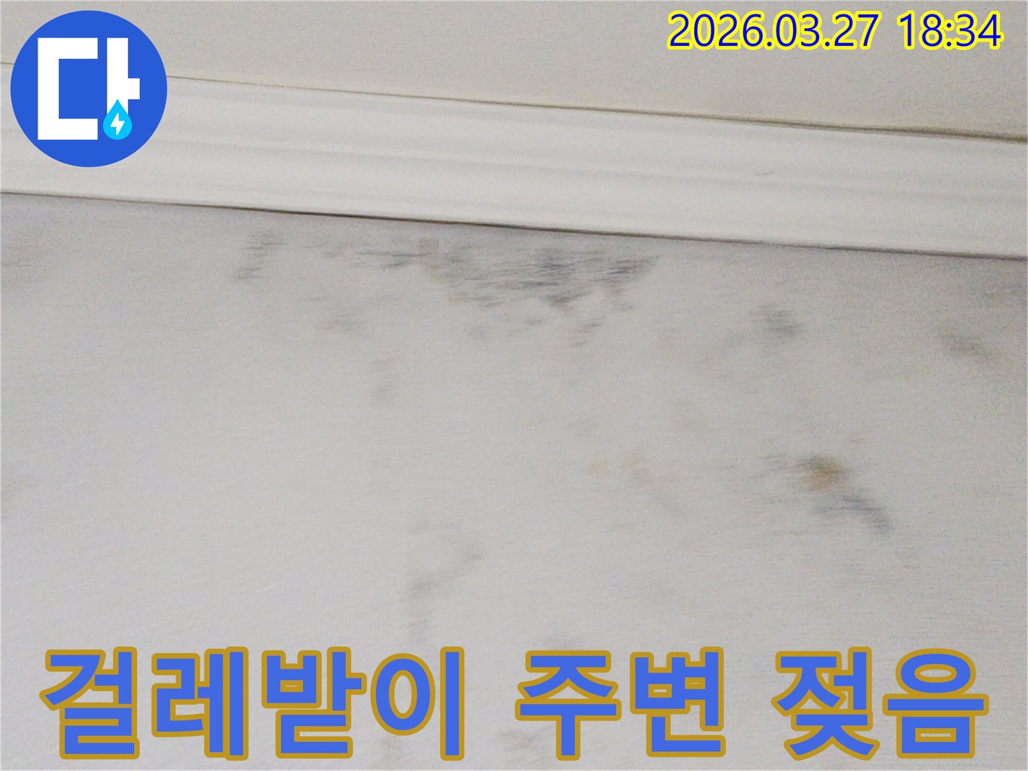 걸레받이-주변으로-물이-스며들어-벽면이-젖고-변색된-모습을-보여주는-사진입니다.