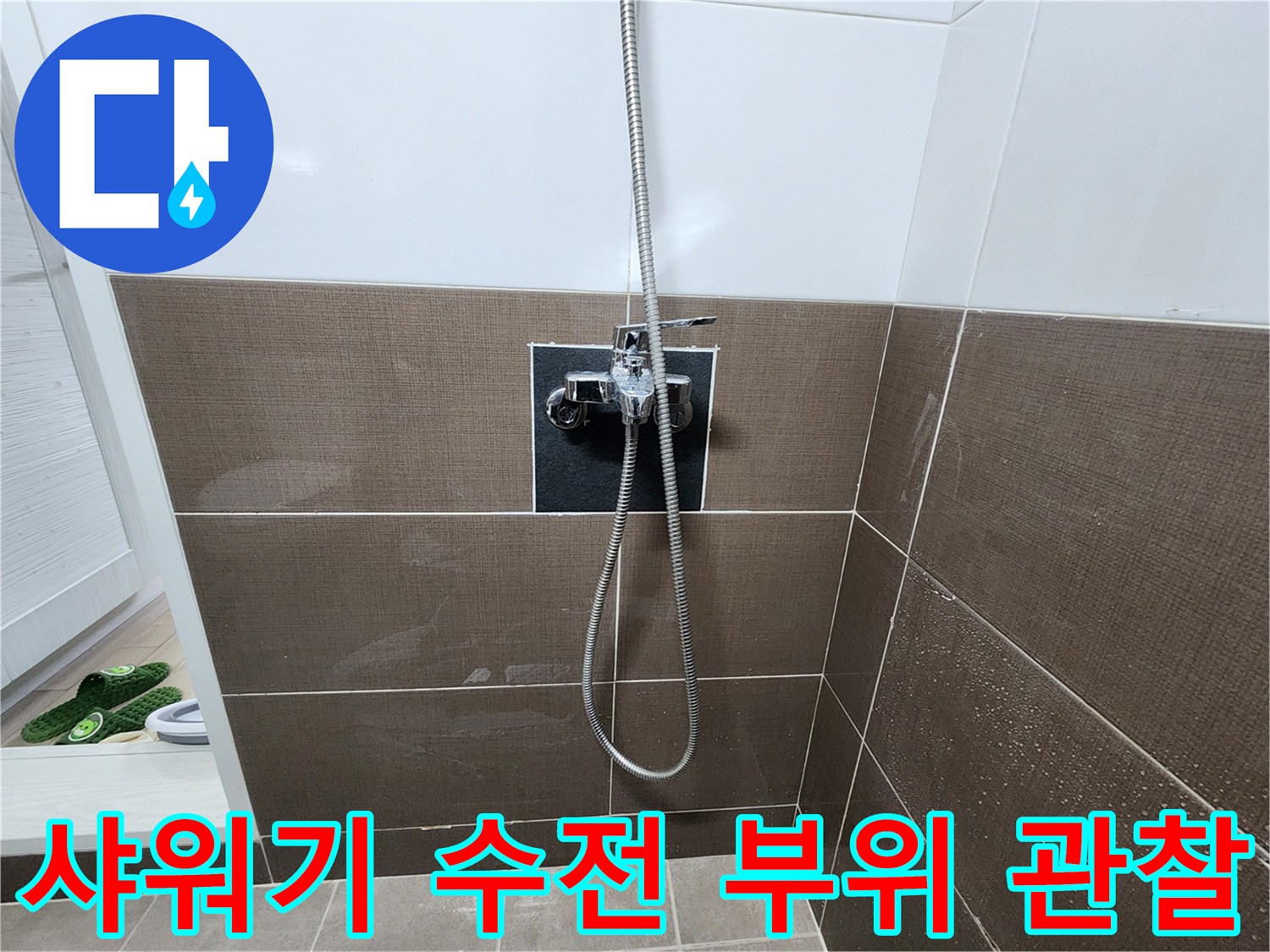 벽면에 설치된 샤워기 수전의 밸브와 호스 연결부를 가까이서 본 모습입니다.