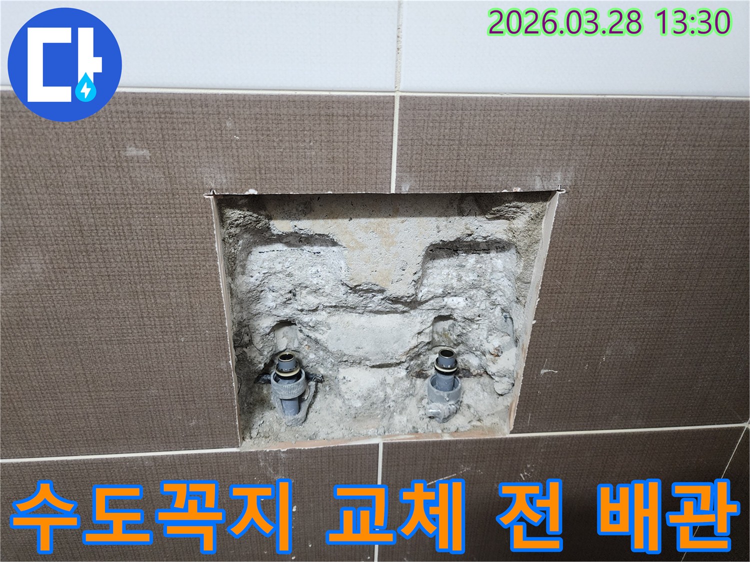 중랑구 묵동 욕실의 수도꼭지 교체 전-벽면 타일을 제거하고 내부 매립 배관의 상태를 점검하는-공사 현장의 한 장면입니다.