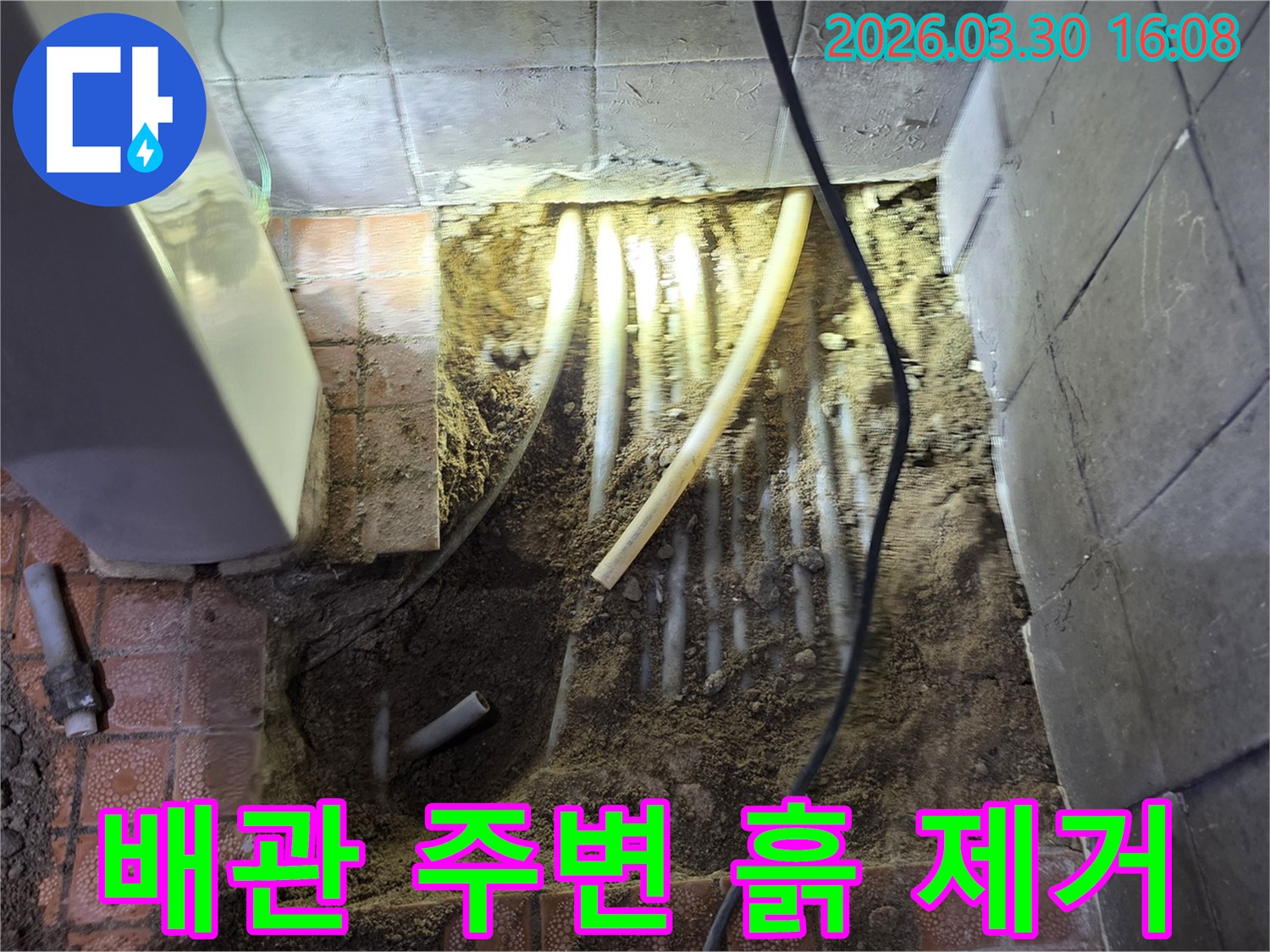 경기 파주시 문산읍 누수 공사 현장에서-바닥을 파쇄하고-배관 주변의 흙을 조심스럽게 제거하며-누수 지점을 확인하는 모습입니다.