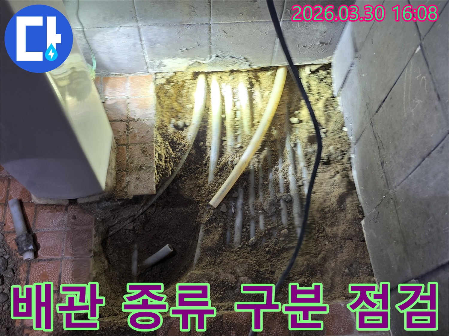 경기 파주시 문산읍 누수 현장에서-바닥 파쇄 후 노출된-온수 및 냉수 배관을 구분하여 점검하는 모습입니다.